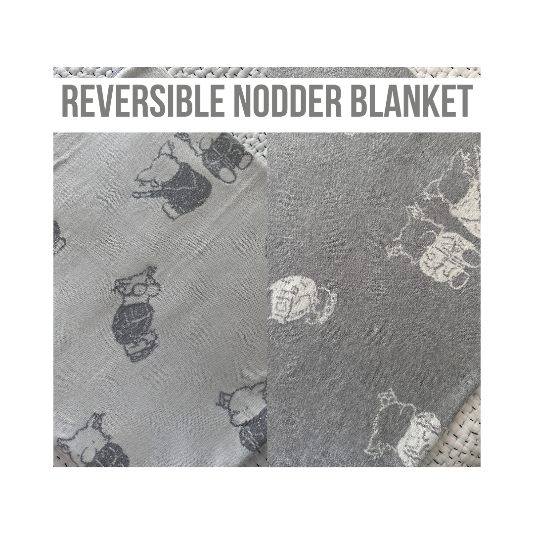 The Nodder Blanket is reversible with gray background and white characters on one side and a white background and gray characters on the other side.